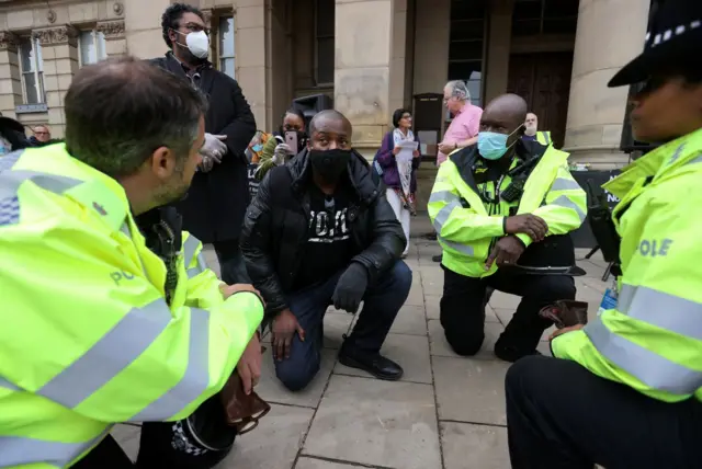 Police officers taking the knee