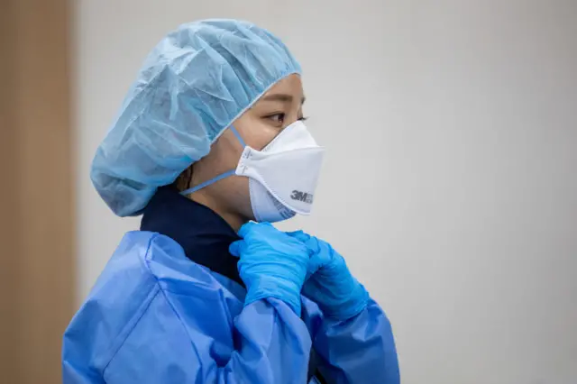 Medical worker in protective gear wears the newly supplied ice scarf at a temporary coronavirus (COVID-19) testing station in Seoul, South Korea,