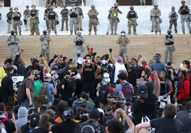 A man shouts from a bullhorn