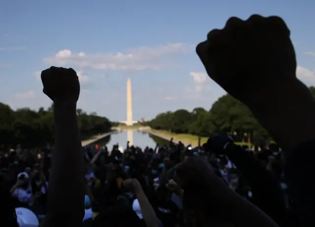 Protesters took a knee and held fists as they faced the direction of the Washington Monument and the White House