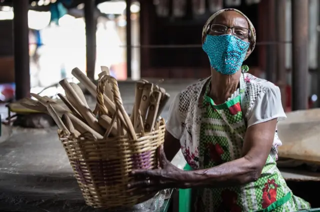 A market trader in Maputo wears a face mask