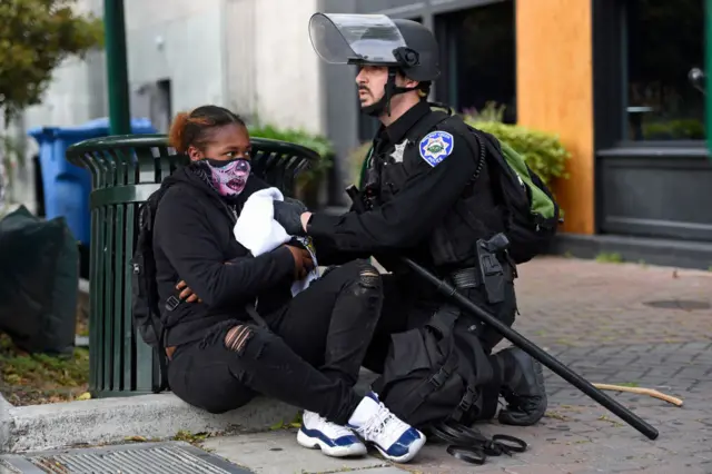 A Walnut Creek Police officer applies pressure to a bullet wound after a young female was shot in the left arm at the corner of Olympic Blvd. and Locust Street in downtown Walnut Creek, Calif., on Sunday, May 31, 2020.