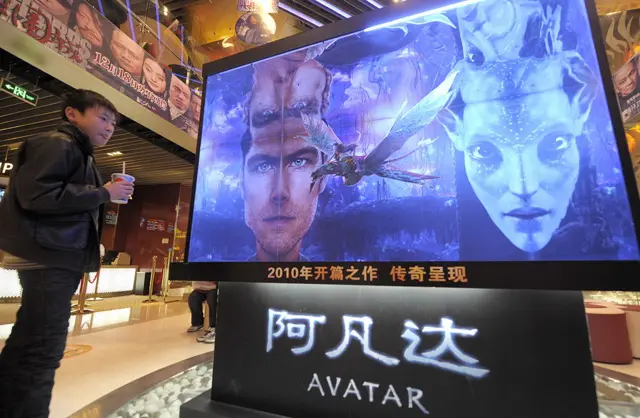 A boy in Beijing looks at a movie poster of Avatar in 2010