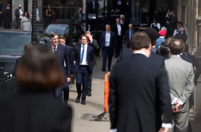 MPs queue up outside the Houses of Parliament to vote in the Commons