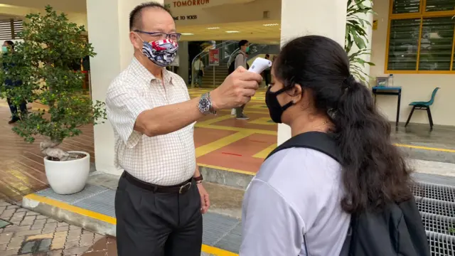 Students having their temperature checked