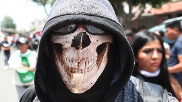 Man wearing a face mask with a skull printed on it