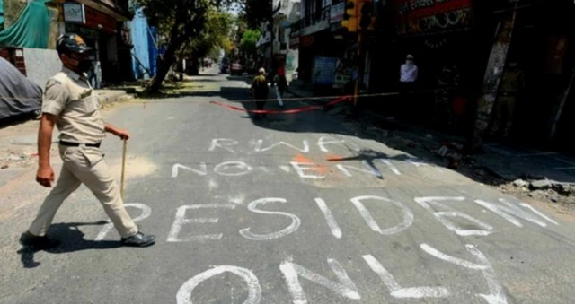 An Indian police man patrolling a neighbourhood