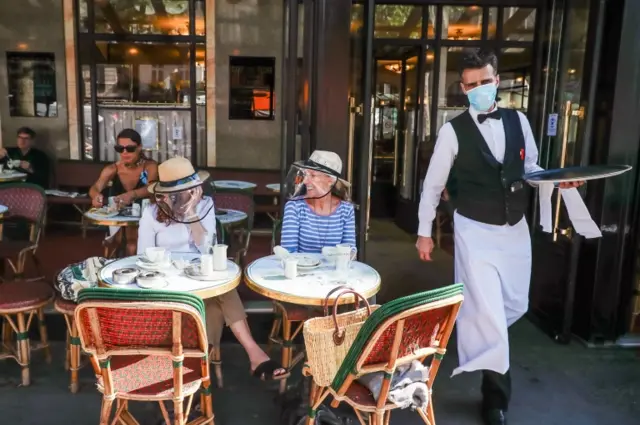 Customers wear face shields while sitting in a restaurant in Paris