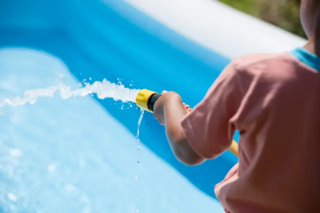 A paddling pool being filled with water