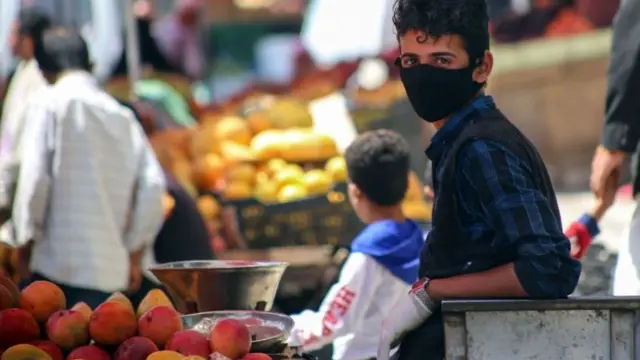 A Yemeni youth wears a protective mask at a street market in Taiz, Yemen (1 June 2020)