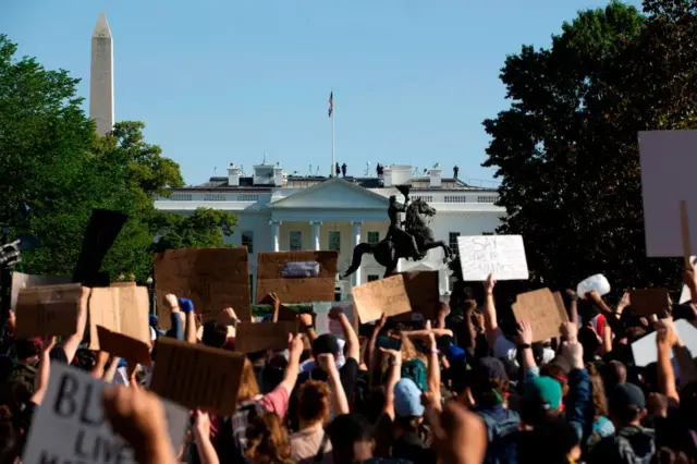 Demonstrators hold up placards protest outside of the White House, over the death of George Floyd in Washington D.C. on June 1, 2020.