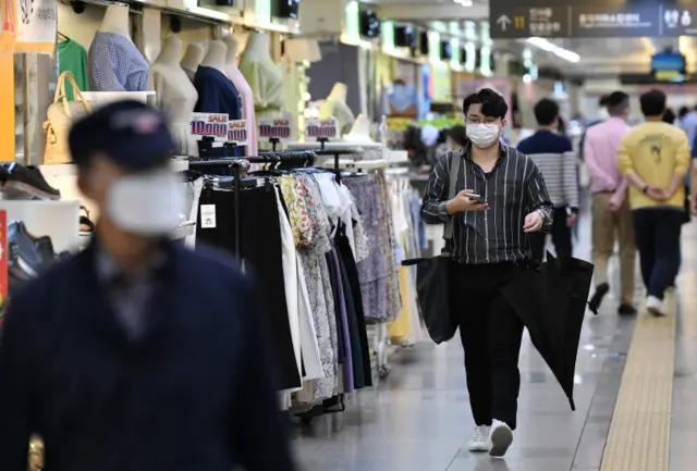 Pedestrians wearing face masks walk through an underground shopping area in central Seoul on June 2, 2020.