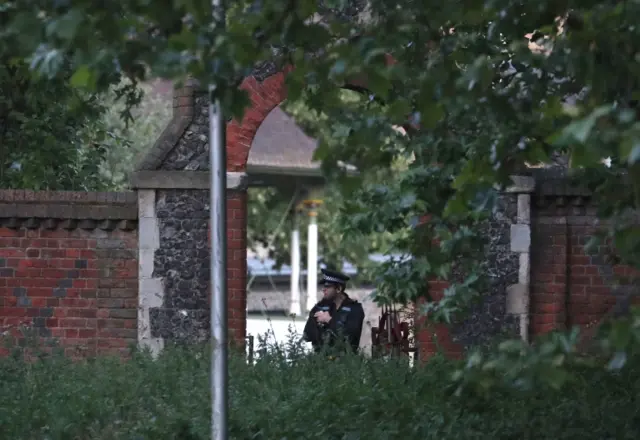 Police officer guards park entrance