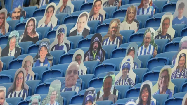 Cardboard cut-outs with photographs of Brighton supporters