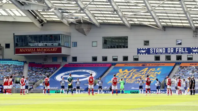 Arsenal and Brighton players stand for a minute's silence