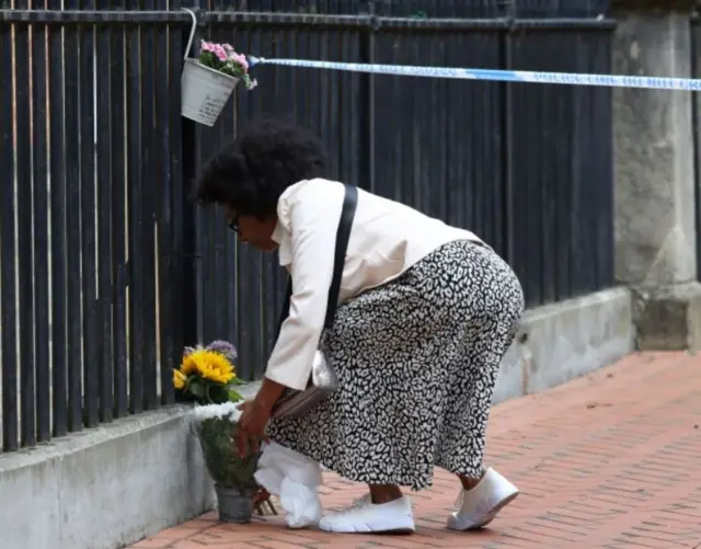 Woman leaving flowers at scene