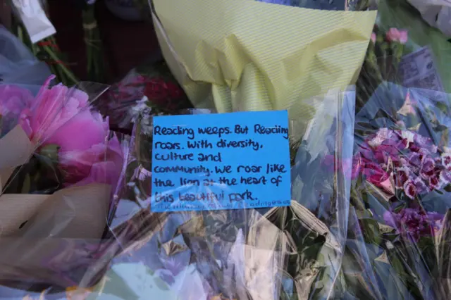 A message on flowers left in Reading town centre: "Reading weeps. But Reading roars. With diversity, culture and community. We roar like the lion at the heart of this beautiful park."