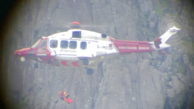 Injured climber being winched onboard a helicopter