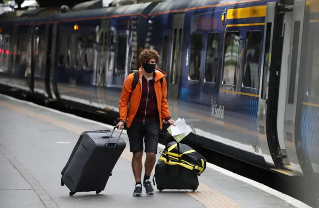 Man wearing mask next to train