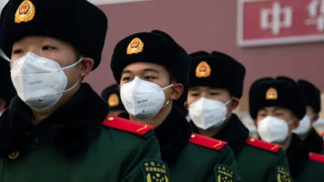 Chinese policemen wearing face masks