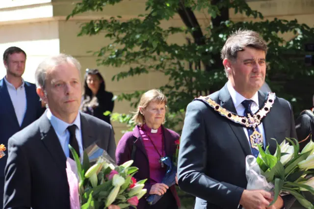 (left to right) Reading East MP Matt Rodda, the Bishop of Reading the Rt Revd Olivia Graham and Councillor David Stevens lay flowers in Reading town centre