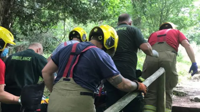 Paramedics and fire crews carrying the stretcher