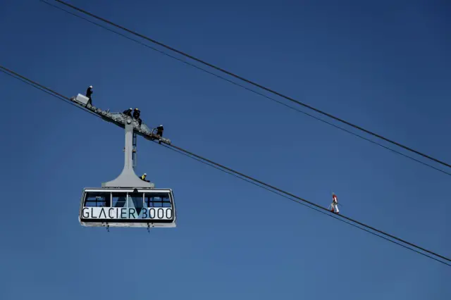 Swiss acrobat Freddy Nock balances blindfolded on the carrying cable of a cable car during the "Glacier 3000" Air show, an event marking the reopening of the Alpine facilities on 23 June 2020 above Les Diablerets