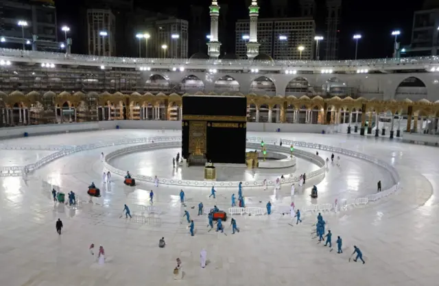 In this file photo taken on 24 April 2020, sanitation workers disinfect the area around the Kaaba in Mecca's Grand Mosque, on the first day of the Islamic holy month of Ramadan