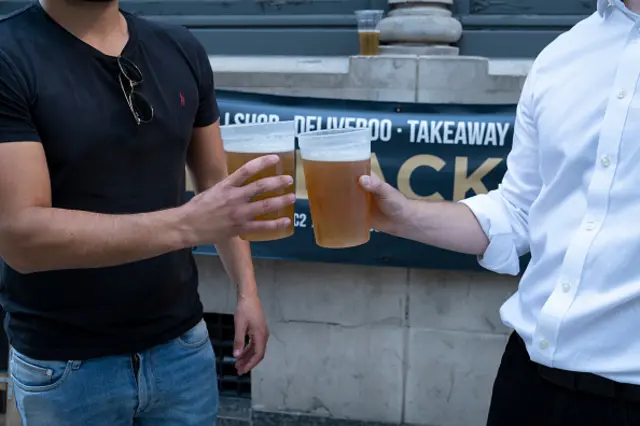 Two drinkers pose for a photograph outside a pub in the City of London