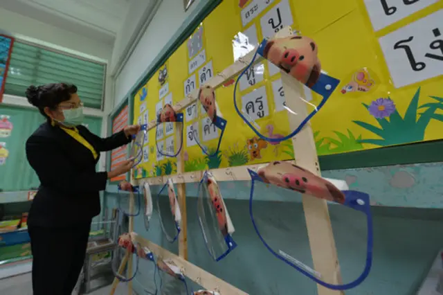 A teacher prepares face masks for children in Bankok