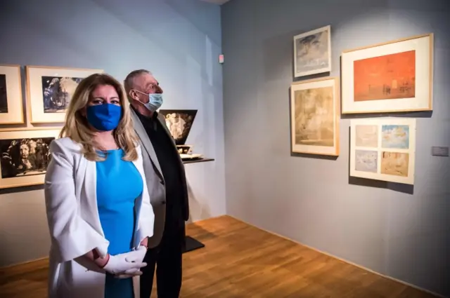 Slovak president Zuzana Caputova (L) and Slovak actor Martin Huba wear face masks as they visit the Slovak National Gallery in Bratislava on May 21