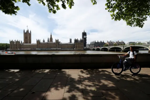 Cyclist passes the Houses of Parliament