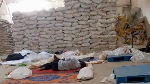 Men sleeping on the floor in a rice mill