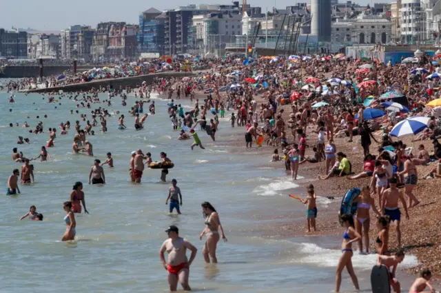 People enjoy warm weather on the beach, as the spread of the coronavirus disease continues, in Brighton, Britai