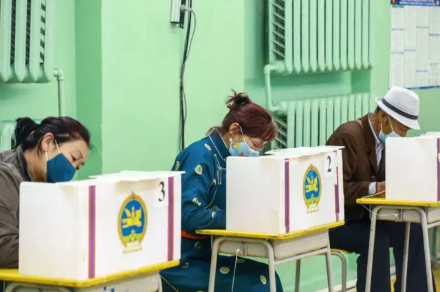 People wearing face masks vote at a polling station in Ulaanbaatar, the capital of Mongolia on June 24, 2020.