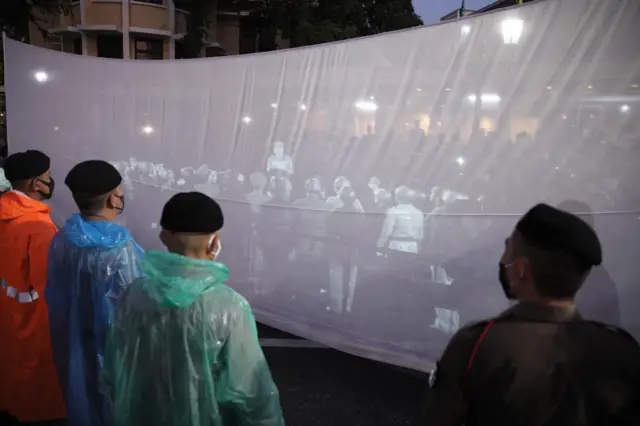 People watch replay of events from 88 years ago on a screen. Picture by Wasawat Lukharang/BBC Thai