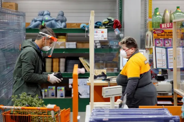 A customer wearing a face mask shops in a hardware store on 14 April