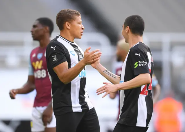 Dwight Gayle celebrates scoring their first goal with Miguel Almiron