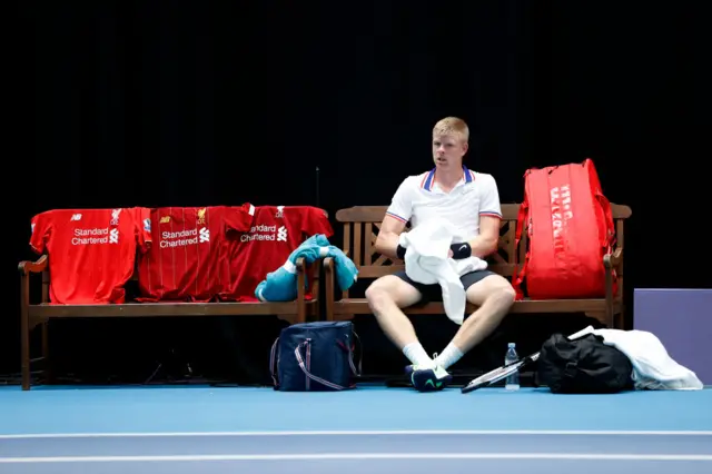 Kyle Edmund sits with three Liverpool shirts