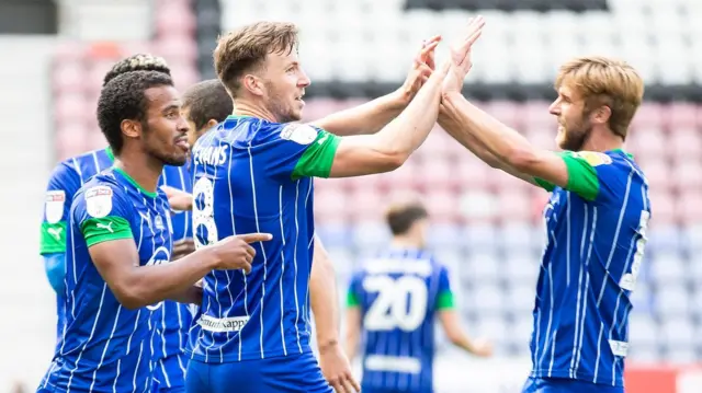 Wigan players celebrate a goal