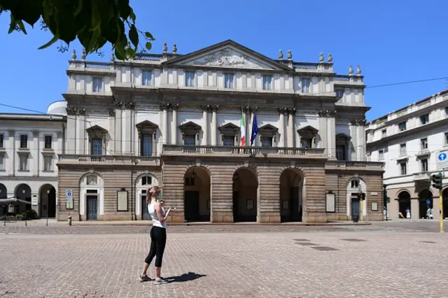 A woman stands outside the Teatro alla Scala