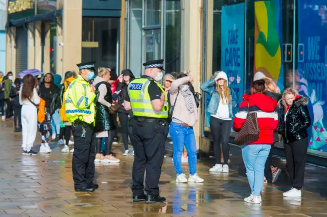 Police supervise the queue outside Primark in Edinburgh's Princes Street