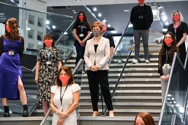 Sturgeon and shop staff wearing face coverings