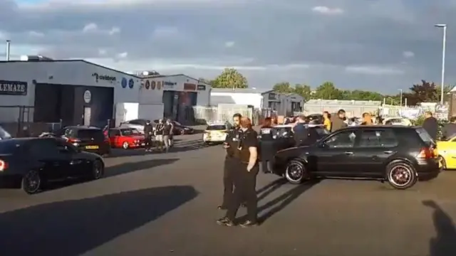 Screengrab from video showing police officers at the gathering of cars