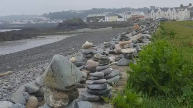 Pebble stacks lining wall
