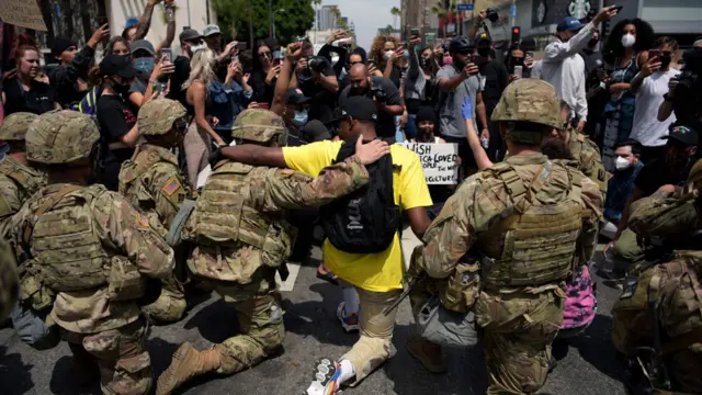 Protesters and members of the Army National Guard kneel together during a demonstration over the death of George Floyd in Los Angeles on June 2, 2020. - Anti-racism protests have put several US cities under curfew to suppress rioting, following the death of George Floyd in police custody.