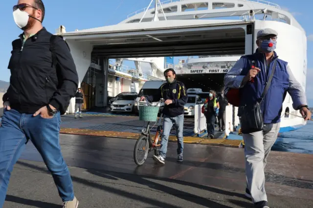 Passengers disembark from the ferry that connects Calabria and Sicily from Villa San Giovanni to Messina on June 3, 2020