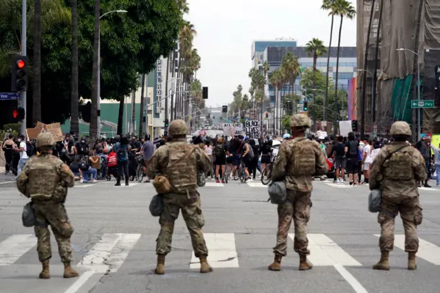 The National Guard watch protesters on Sunset Blvd during a peaceful demonstration