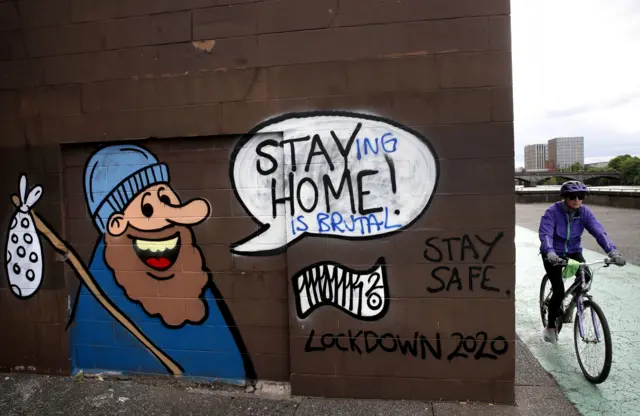 A cyclist passes Coronavirus related graffiti in Glasgow as Scotland is moving into phase one of the Scottish Government"s plan for gradually lifting lockdown.