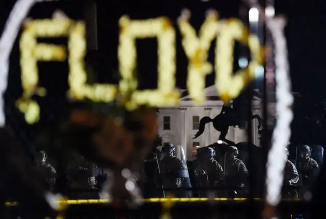 Police in riot gear is seen through the metal fence recently erected in front of the White House on June 2, 2020 in Washington, DC.